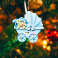 Load image into Gallery viewer, Personalized baby boy Christmas ornament featuring a light blue stroller with glitter details and a smiling baby wearing a blue nightcap. Custom name appears on the top and year on the bottom, making it a perfect Baby’s First Christmas keepsake. This blue resin holiday ornament is ideal for newborn boys, baby shower gifts, and celebrating a special first Christmas memory.