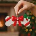 Load image into Gallery viewer, Festive pet themed Christmas ornament designed in a bone shape with a red holiday bow and paw detail. Featuring classic Christmas colors and a warm seasonal background, this ornament adds a joyful and loving touch to pet themed Christmas tree decor. Designed to be personalized with a name and year, making it a meaningful keepsake for pet owners and animal lovers.