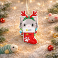 Load image into Gallery viewer, Decorative Christmas ornament shaped like a cat in a stocking with reindeer antlers on a festive background.