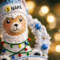 Load image into Gallery viewer, Personalized baby boy llama ornament featuring a cute smiling llama wearing a winter hat and surrounded by a festive wreath with colorful holiday lights. Soft blue and white tones create a cozy winter look. Handwritten personalization includes baby name and Baby’s First Christmas with year. Mostly 2D ornament with raised 3D details on the front only, lightweight and perfect for Christmas trees, nursery decor, and baby keepsakes.