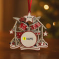 Load image into Gallery viewer, Personalized drum set ornament featuring a detailed red and silver drum kit with cymbals and star accents. Customizable with one name and a year. Crafted from resin with a glossy finish, featuring 3D raised front drum elements and a flat 2D back for balanced hanging. Finished with a satin ribbon. Designed for drummers musicians band members and music themed Christmas tree decor.