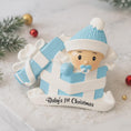 Load image into Gallery viewer, Personalized Baby Boy First Christmas Ornament featuring an adorable baby popping out of a blue gift box with a matching hat and pacifier. The name is displayed on the hat while the year is placed on the ribbon detail, with Baby’s 1st Christmas written along the base. Soft blue and white tones, raised 3D elements, and sweet holiday details make this a charming keepsake. Perfect for newborn boys, baby showers, and celebrating a baby’s very first Christmas season.