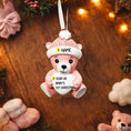 Load image into Gallery viewer, Personalized Pink Teddy Bear Christmas Ornament featuring a sweet baby bear wearing a cozy winter hat and holding a heart that can be customized with a name and year or Babyâs 1st Christmas. This adorable baby girl ornament is designed in soft pink tones, perfect for celebrating a newbornâs first holiday season. A heartwarming keepsake gift for new parents, baby showers, or a special Christmas memory that will be treasured for years to come.