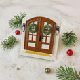 Load image into Gallery viewer, Decorative door with wreaths on a snowy background