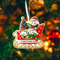 Load image into Gallery viewer, Personalized Christmas ornament with three children in a sleigh and a tree, against a festive background.