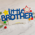 Load image into Gallery viewer, Colorful 'Little Brother' decoration with stars on a marble surface