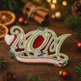 Load image into Gallery viewer, Decorative Christmas ornament shaped like a sleigh with candy cane and holly on a wooden surface.