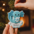Load image into Gallery viewer, Blue dinosaur-shaped ornament with 'I ❤️ Rexelott' text and 'BRADLEY' name, held against a Christmas tree background.
