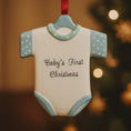 Load image into Gallery viewer, Personalized Baby’s First Christmas Ornament designed as a sweet baby bodysuit with soft blue polka dot sleeves and trim. This ornament features a raised 3D front with textured details and dimensional edges for a charming keepsake look. The baby’s name is added at the top and the year below, creating a meaningful newborn memory gift. Perfect for baby boy first Christmas, newborn celebration, holiday tree decor, and special family milestone ornament.