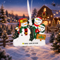 Load image into Gallery viewer, Personalized Christmas ornament with 3 snowmen , against a blurred festive background.