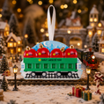 Load image into Gallery viewer, Decorative train ornament with red apples on a Christmas village background