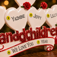 Load image into Gallery viewer, Decorative ornament with hearts and names on a wooden surface