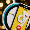 Load image into Gallery viewer, Phone case with TikTok logo and '2 Year' text on a blurred lights background