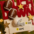Load image into Gallery viewer, Decorative ornament with footballs, helmet, and stars on a red background