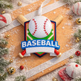 Load image into Gallery viewer, Personalized baseball Christmas ornament featuring a classic baseball and crossed bats design on a shield style background, customizable name area on the front banner and customizable year area on the baseball, glossy finish with raised 3D front details and flat 2D back, white hanging ribbon, displayed on a snowy baseball field themed holiday background with pine branches and festive decorations.