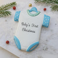 Load image into Gallery viewer, Personalized Baby’s First Christmas Ornament designed as a sweet baby bodysuit with soft blue polka dot sleeves and trim. This ornament features a raised 3D front with textured details and dimensional edges for a charming keepsake look. The baby’s name is added at the top and the year below, creating a meaningful newborn memory gift. Perfect for baby boy first Christmas, newborn celebration, holiday tree decor, and special family milestone ornament.