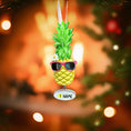 Load image into Gallery viewer, Pineapple ornament with sunglasses on a Christmas tree with blurred lights in the background