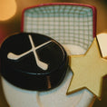 Load image into Gallery viewer, Close-up of a hockey puck with a star and net background