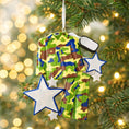 Load image into Gallery viewer, A glossy resin Army soldier uniform ornament in green brown and blue camouflage colors features a military jacket and pants shape with raised buttons and pockets, white and blue star accents, light snow texture, a smooth painted cartoon style finish, and handwritten personalization showing a name and year on the attached tag, designed as a mostly 2D ornament with raised 3D details on the front only for Christmas tree decor.