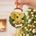 Load image into Gallery viewer, Dog Christmas ornament with a wreath and Santa hat against a festive background