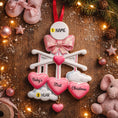 Load image into Gallery viewer, Personalized Baby Girl First Christmas Ornament featuring a dimensional 3D front design with pink glitter bow, heart charms, and hanging cloud detail. The baby’s name is added on the top circle and the year on the cloud, creating a meaningful keepsake. Soft pink tones, layered hearts reading Baby’s First Christmas, and festive holiday accents make it perfect for newborn girl gifts, baby shower presents, and treasured Christmas tree memories.
