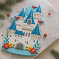 Load image into Gallery viewer, Personalized Princess Castle Christmas Ornament featuring a charming white fairytale castle with blue rooftops and red flags, surrounded by colorful floral details. Customizable with name at the base and year on the castle front, this magical princess castle ornament is perfect for celebrating a special little girl.