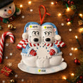 Load image into Gallery viewer, Personalizable polar bear ornament with scarves and candy canes on a wooden background with Christmas decorations.