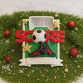 Load image into Gallery viewer, Decorative ornament with soccer ball, shoes, and 'Score' text on a grassy background.