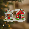 Load image into Gallery viewer, Decorative Christmas ornament shaped like two houses with a banner reading 'From Our House to Yours' on a blurred Christmas tree background.
