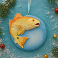 Load image into Gallery viewer, Goldfish ornament on a blue background with Christmas decorations