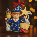 Load image into Gallery viewer, A cute blue-robed wizard boy Christmas ornament featuring a magic wand, star, open book and owl, perfect for kids. Personalized with name and year. Ideal holiday tree decoration for little wizard fans and magical Christmas gifts.