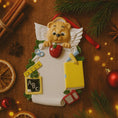 Load image into Gallery viewer, Decorative teacher angel ornament with a teddy bear holding an apple, surrounded by Christmas decorations on a wooden surface.
