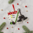 Load image into Gallery viewer, Hockey-themed Christmas ornament with customizable text on a light gray background with holiday decorations.