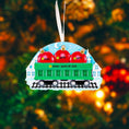 Load image into Gallery viewer, Decorative train ornament with red bags and customizable text on a blurred Christmas tree background.