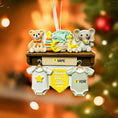 Load image into Gallery viewer, Decorative baby ornament with teddy bear, elephant, and giraffe on a shelf with baby onesies below, against a blurred Christmas tree background.