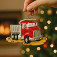 Load image into Gallery viewer, Red truck ornament held by a hand with a blurred Christmas tree in the background