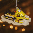 Load image into Gallery viewer, Decorative ornament of a yellow snowmobile on a tree with blurred lights in the background