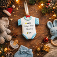 Load image into Gallery viewer, Personalized Baby’s First Christmas Ornament designed as a sweet baby bodysuit with soft blue polka dot sleeves and trim. This ornament features a raised 3D front with textured details and dimensional edges for a charming keepsake look. The baby’s name is added at the top and the year below, creating a meaningful newborn memory gift. Perfect for baby boy first Christmas, newborn celebration, holiday tree decor, and special family milestone ornament.
