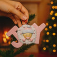 Load image into Gallery viewer, Decorative ornament with a baby face and 'JOY' letters against a festive background.