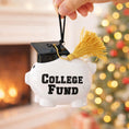 Load image into Gallery viewer, Piggy bank ornament with 'College Fund' text and graduation cap against a festive background