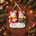 Load image into Gallery viewer, Decorative Christmas ornament of two mice holding a music note and candy cane on a wooden background with festive decorations.