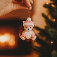 Load image into Gallery viewer, Personalized Pink Teddy Bear Christmas Ornament featuring a sweet baby bear wearing a cozy winter hat and holding a heart that can be customized with a name and year or Babyâs 1st Christmas. This adorable baby girl ornament is designed in soft pink tones, perfect for celebrating a newbornâs first holiday season. A heartwarming keepsake gift for new parents, baby showers, or a special Christmas memory that will be treasured for years to come.