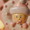 Load image into Gallery viewer, ornament figure with a pink hat on a textured surface