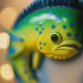 Load image into Gallery viewer, Close-up of a green and blue fish-shaped object with a blurred background