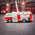 Load image into Gallery viewer, Fire truck ornament with customizable name on a blurred fire station background