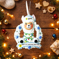 Load image into Gallery viewer, Personalized baby boy llama ornament featuring a cute smiling llama wearing a winter hat and surrounded by a festive wreath with colorful holiday lights. Soft blue and white tones create a cozy winter look. Handwritten personalization includes baby name and Baby’s First Christmas with year. Mostly 2D ornament with raised 3D details on the front only, lightweight and perfect for Christmas trees, nursery decor, and baby keepsakes.