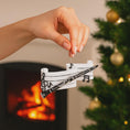 Load image into Gallery viewer, Hand holding a decorative ornament with musical notes in front of a fireplace and Christmas tree.