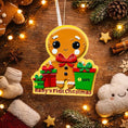 Load image into Gallery viewer, Decorative ornament shaped like a gingerbread man with 'Baby's First Christmas' text on a wooden background with festive decorations.