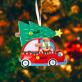 Load image into Gallery viewer, Festive dog themed Christmas ornament featuring a happy puppy riding in a red car with a Christmas tree on top. Designed with playful holiday colors and a cozy winter setting, this ornament brings a joyful pet themed touch to Christmas tree decor. Includes personalization options for name and year, making it a meaningful keepsake for dog lovers and pet families.