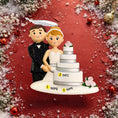 Load image into Gallery viewer, Wedding cake topper with bride and groom figurines on a red background with decorative elements.